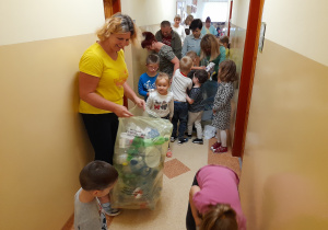 Dzieci i pracownicy przedszkola porządkują korytarz. Na zdjęciu Ania, Karol, Iwo i pani Agnieszka, w tle pozostali.